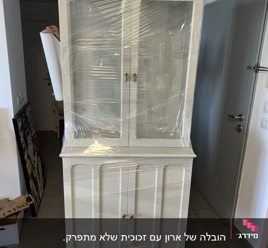 ארון ויטרינה גדול עטוף בניילון נצמד להגנה לפני הובלה